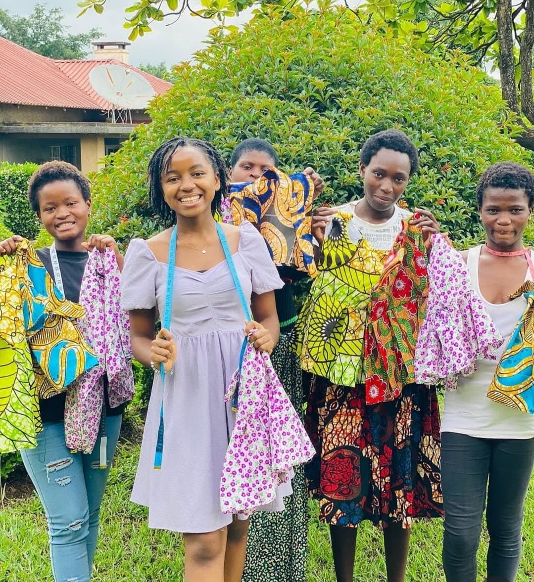 Young women showing their sewn garments